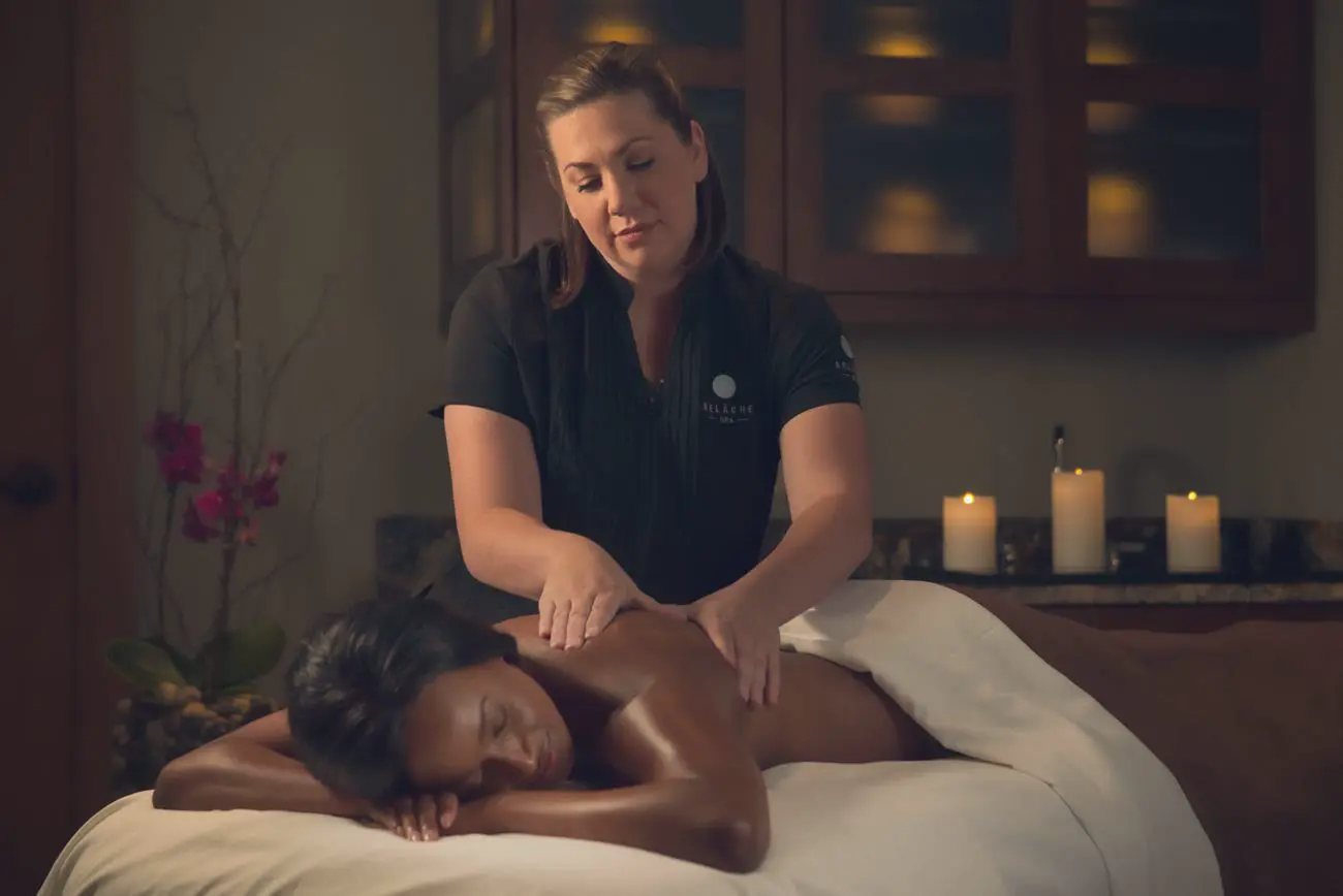 A Relâche Spa therapist works slow, firm pressure into a guest's shoulder during a massage